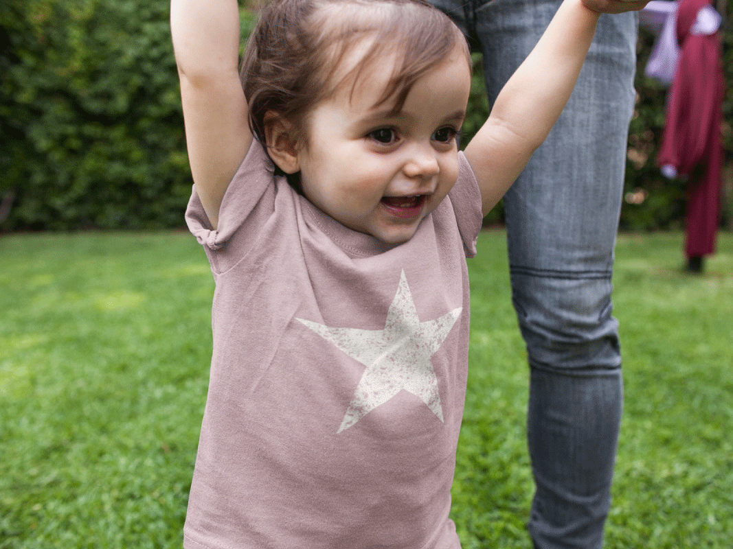 Child wearing a pink shirt with a star design outdoors