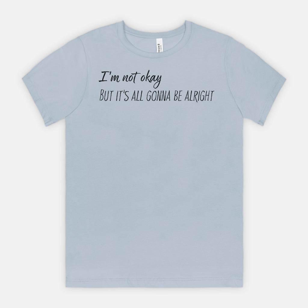 Light blue t-shirt with text, "I'm not okay but it's all gonna be alright" on a white background