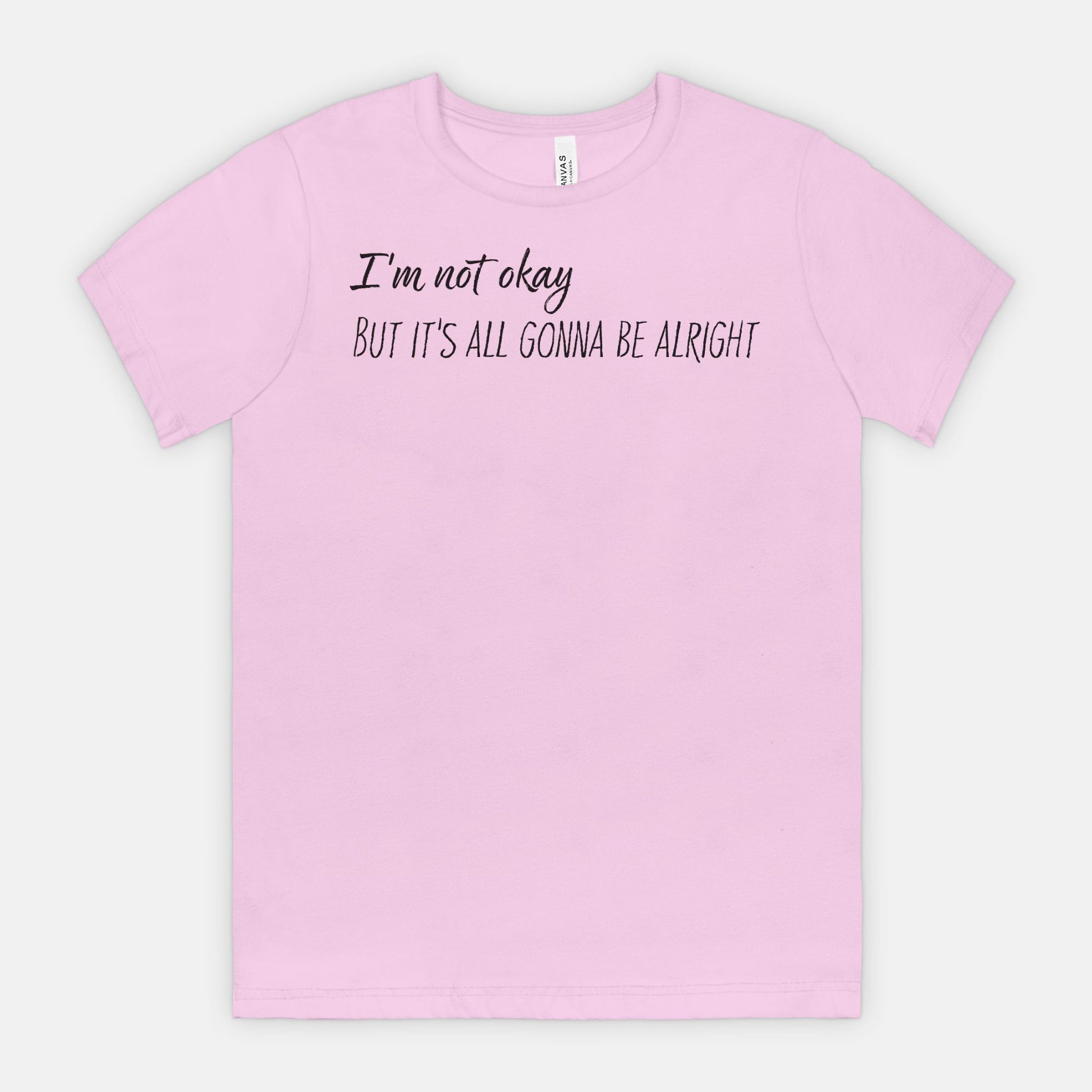 Lilac t-shirt with text 'I'm not okay, but it's all gonna be alright' on a white background