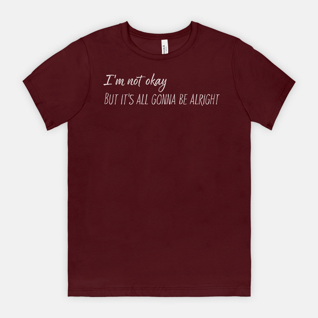 Maroon t-shirt with white text "I'm not okay but it's all gonna be alright" on a white background