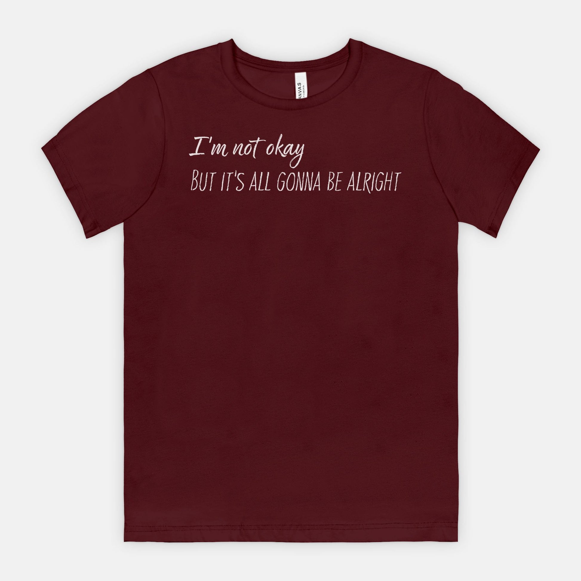 Maroon t-shirt with white text "I'm not okay but it's all gonna be alright" on a white background