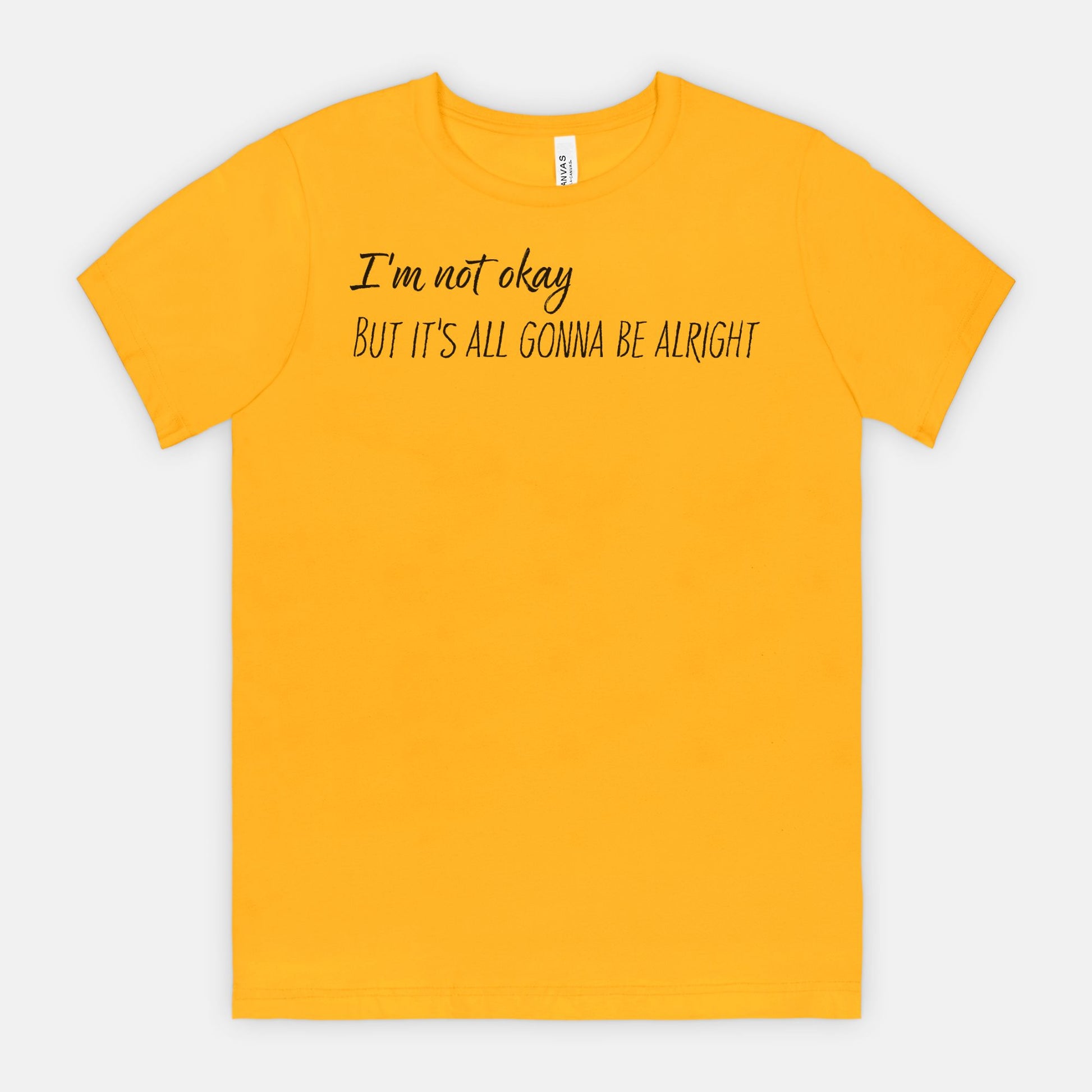 Yellow t-shirt with text 'I'm not okay But it's all gonna be alright' on a white background