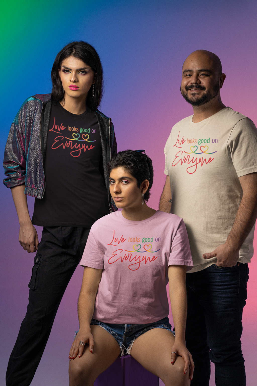 Three people wearing t-shirts with a colorful text "Love Looks Good on Everyone".