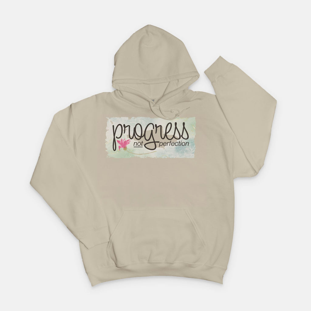Sand hoodie with 'progress not perfection' text on a white background