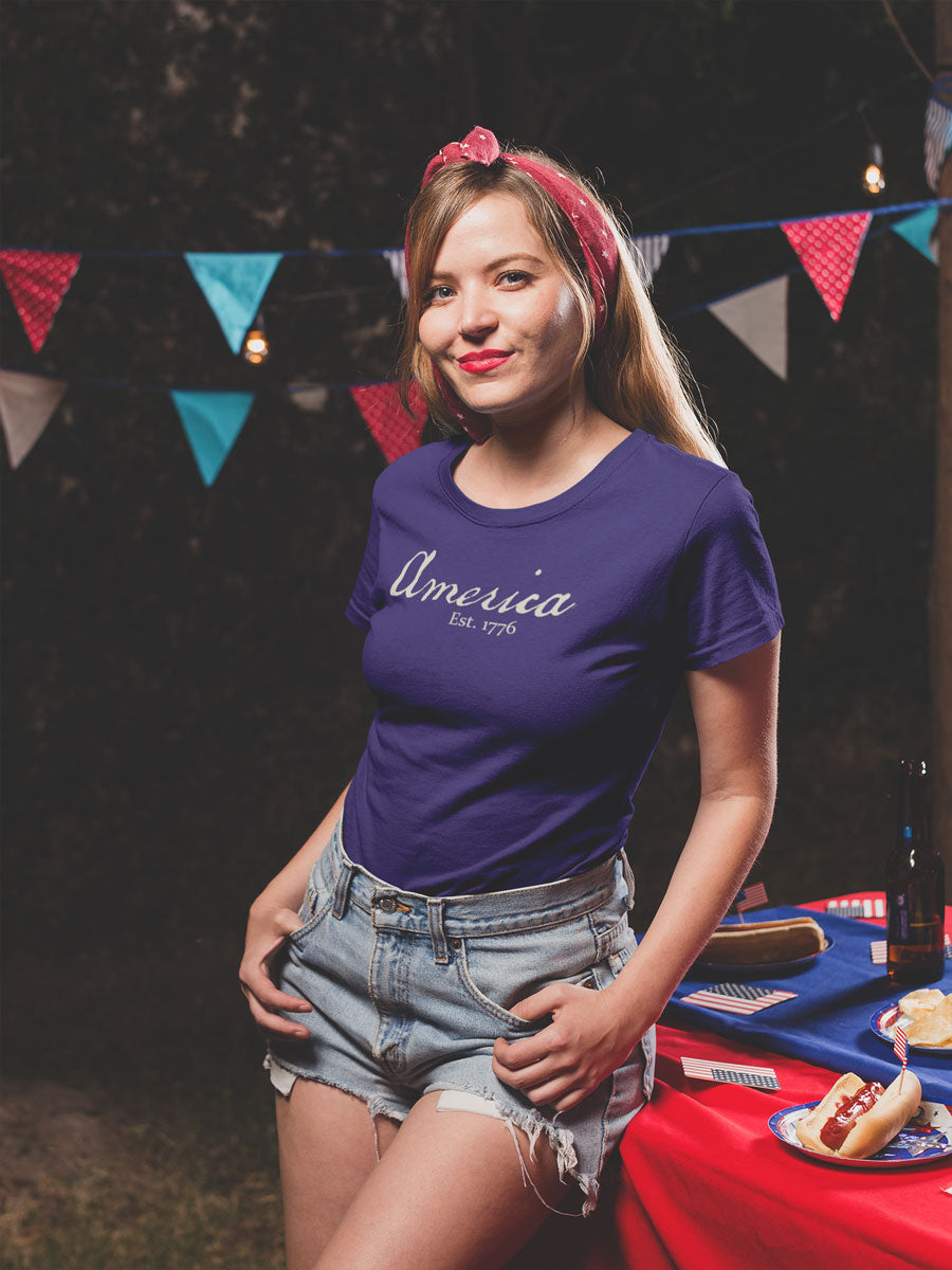 Model wearing Vintage America Est. 1776 heritage script patriotic design on Bella Canvas 3001 Team Navy T-shirt by Red Rock Chaos