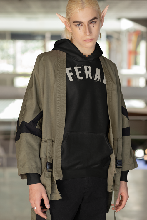 Elf Model wearing a Gildan 18500 black hoodie featuring the word “FERAL” in bold distressed brown lettering, designed by Red Rock Chaos for a minimalist wild-at-heart style.