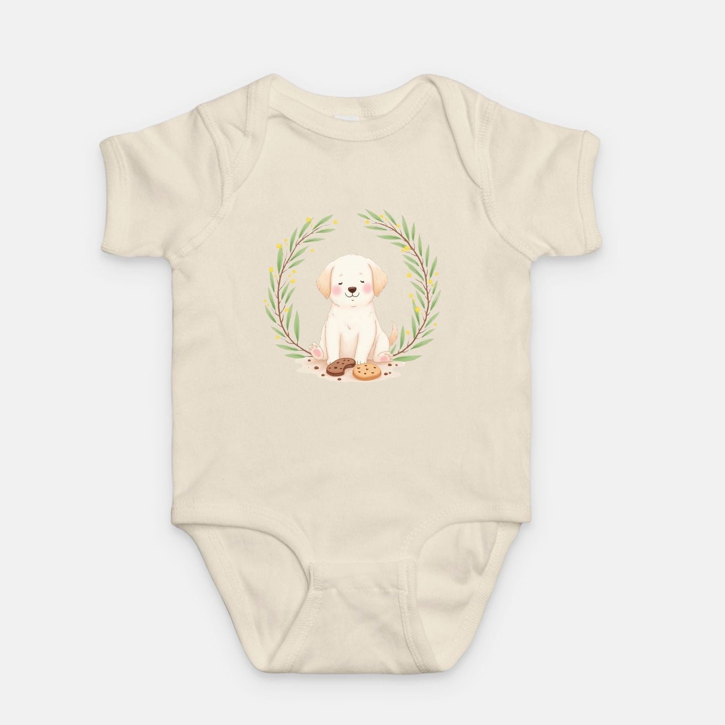 Little Chaos Crew puppy sitting with eyes closed surrounded by cookies and crumbs inside green leafy wreath, minimalist baby cream onesie design.